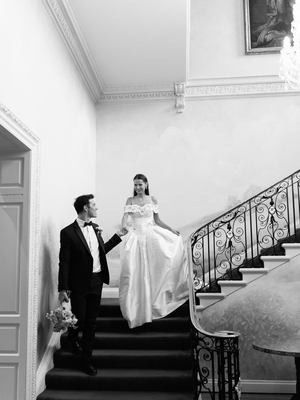 A black and white image of a wedding ceremony with huge floral backdrop at Palé Hall in Wales. Planned by Soirée Studio.