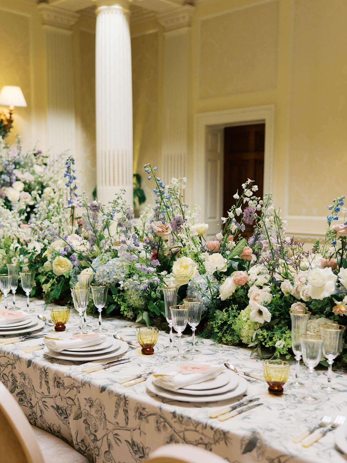 A colour image of summer wedding flowers with peach and pink tones at a wedding planned by design-led wedding planner soiree studio.